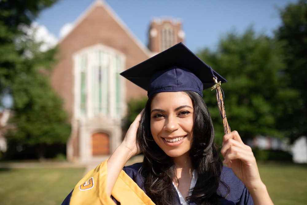 a woman in a cap and gown holding a diploma
