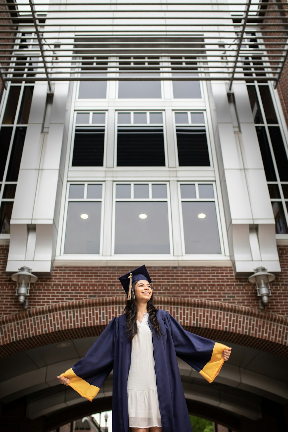 a woman in a graduation gown standing in front of a building