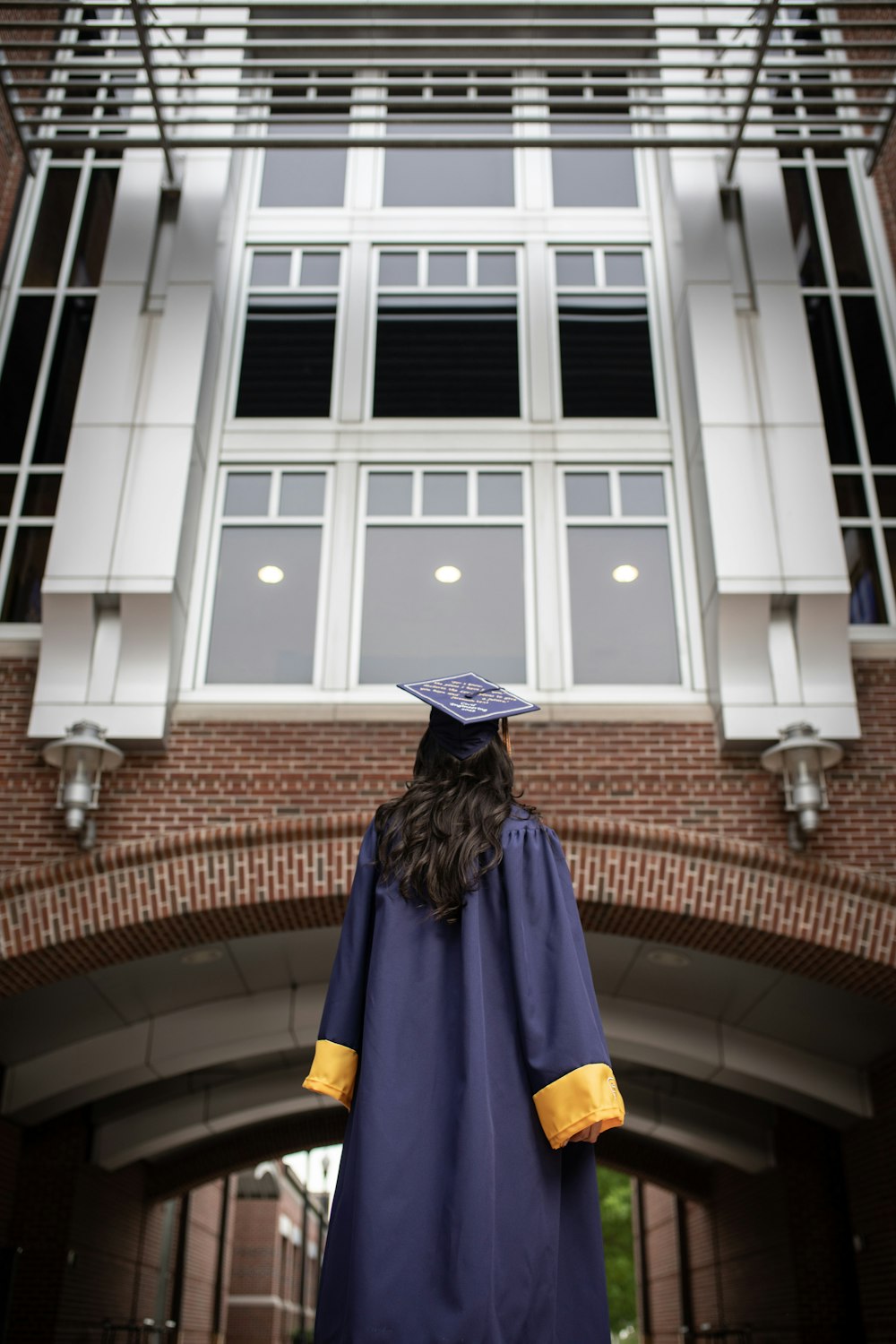 a person in a graduation gown standing in front of a building