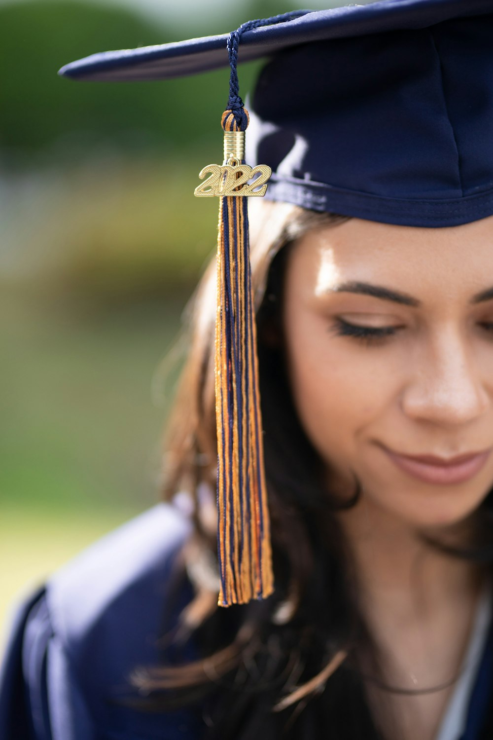 a woman in a cap and gown looking at her cell phone