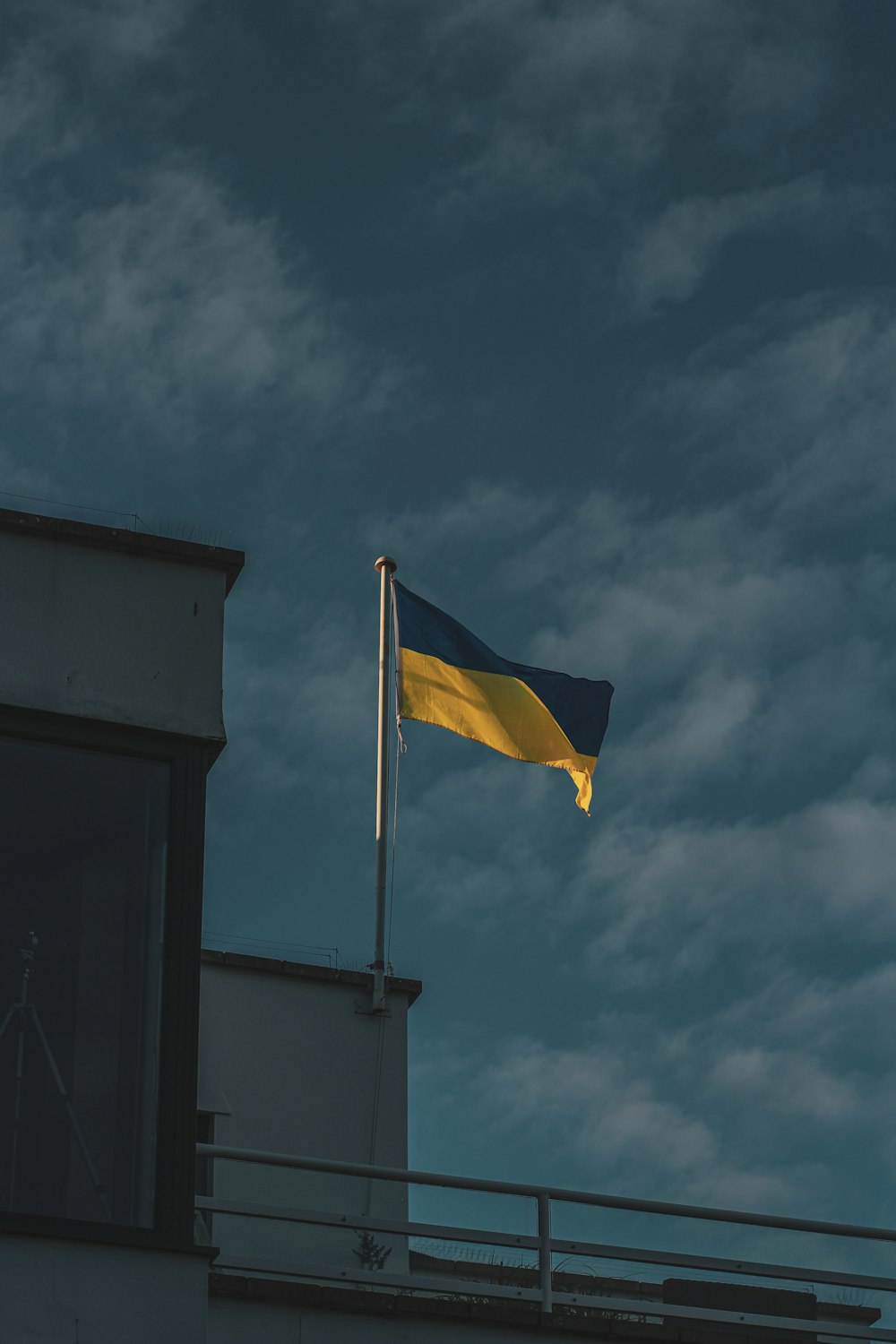 a flag flying on top of a building under a cloudy sky