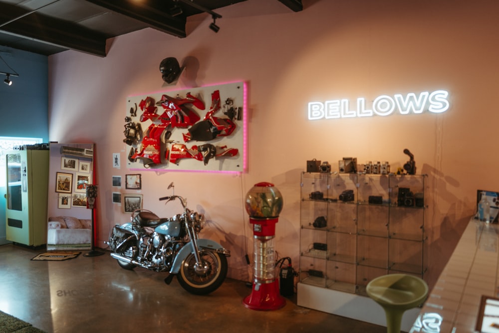 a motorcycle is parked in a room with a neon sign