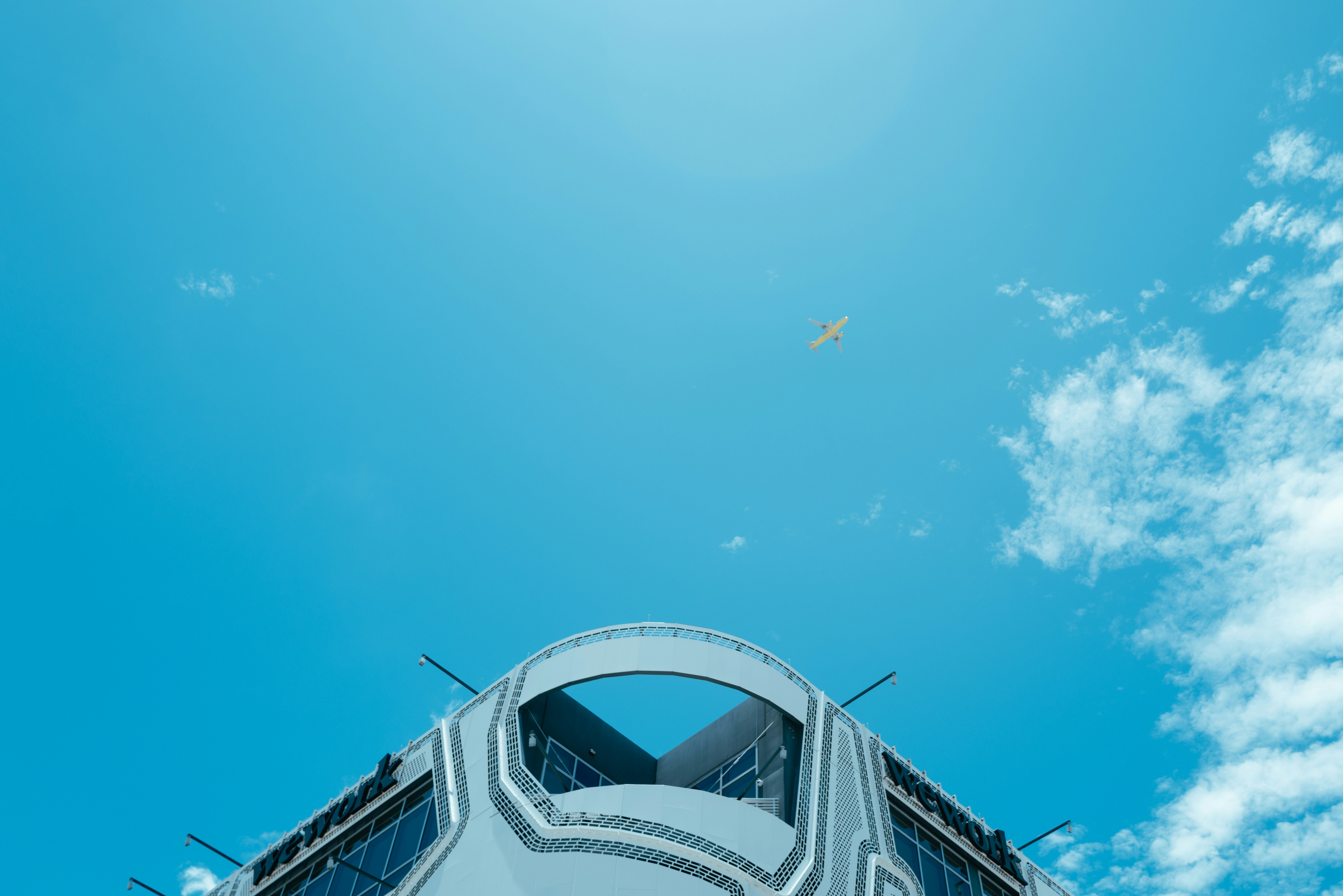 Modern aircraft flying above clouds in blue sky