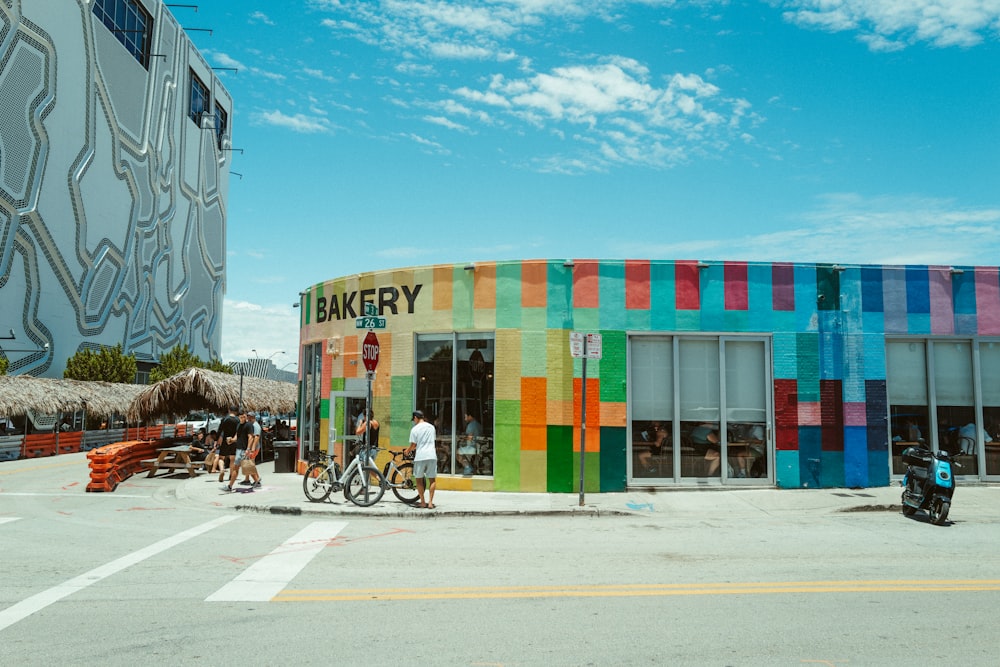 a multicolored building with people standing outside of it