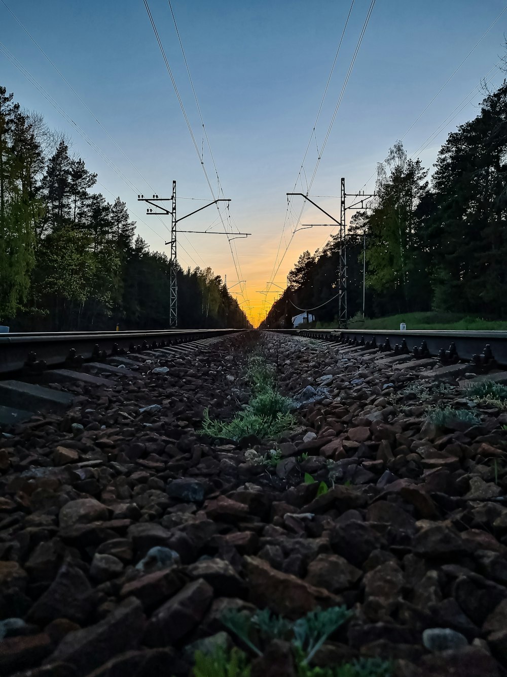 the sun is setting on a train track