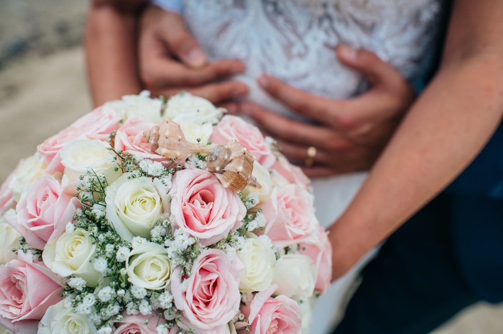 a bride and groom holding a bouquet of flowers