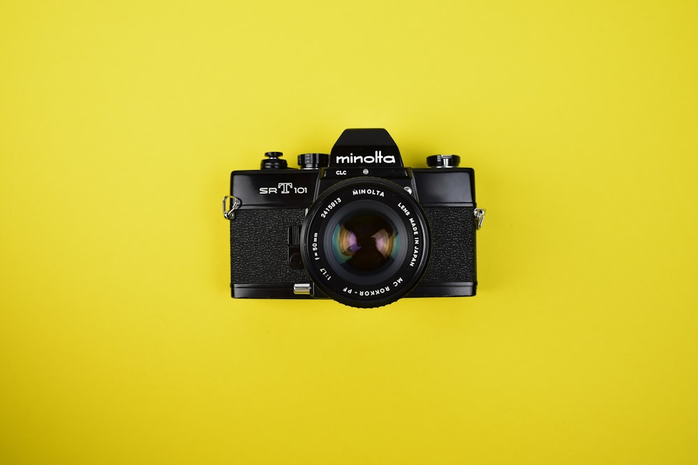 a black camera on a yellow background
