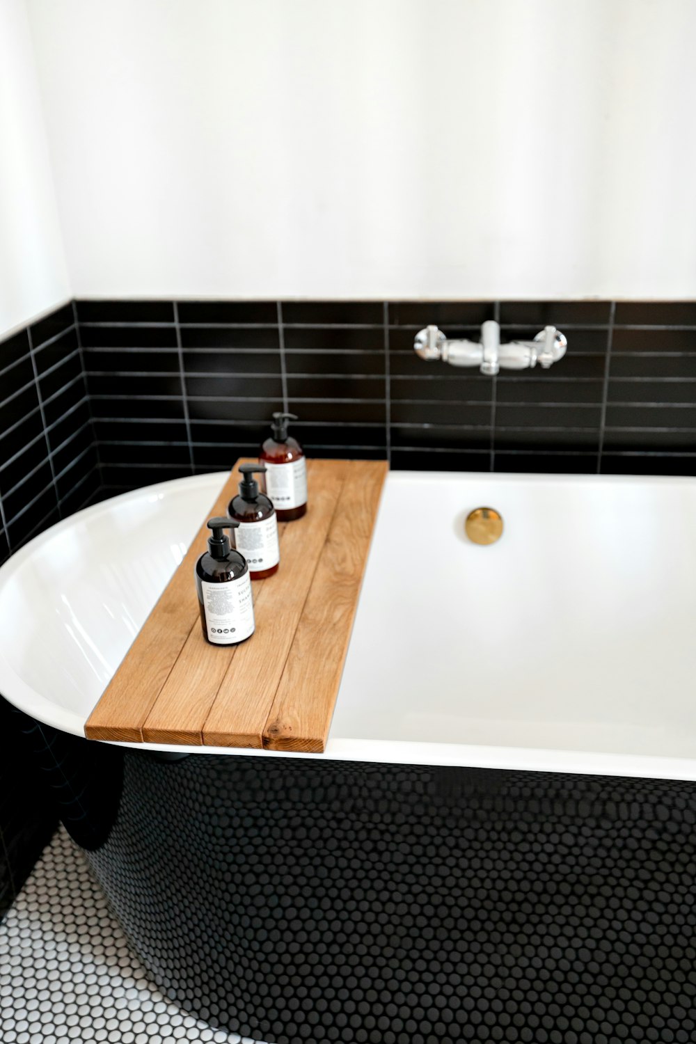 a bathtub with a wooden tray in the middle of it