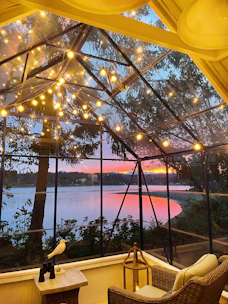 Cozy outdoor seating at sunset overlooking Lake Pichola, with warm lanterns glowing.