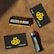Several items are arranged on a brown textured surface, including a black and yellow gift card, a lighter with branding, and a box labeled 'Buzzed Buds'. The logo features a stylized bee symbol.