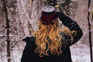 a woman standing in the snow with her back to the camera