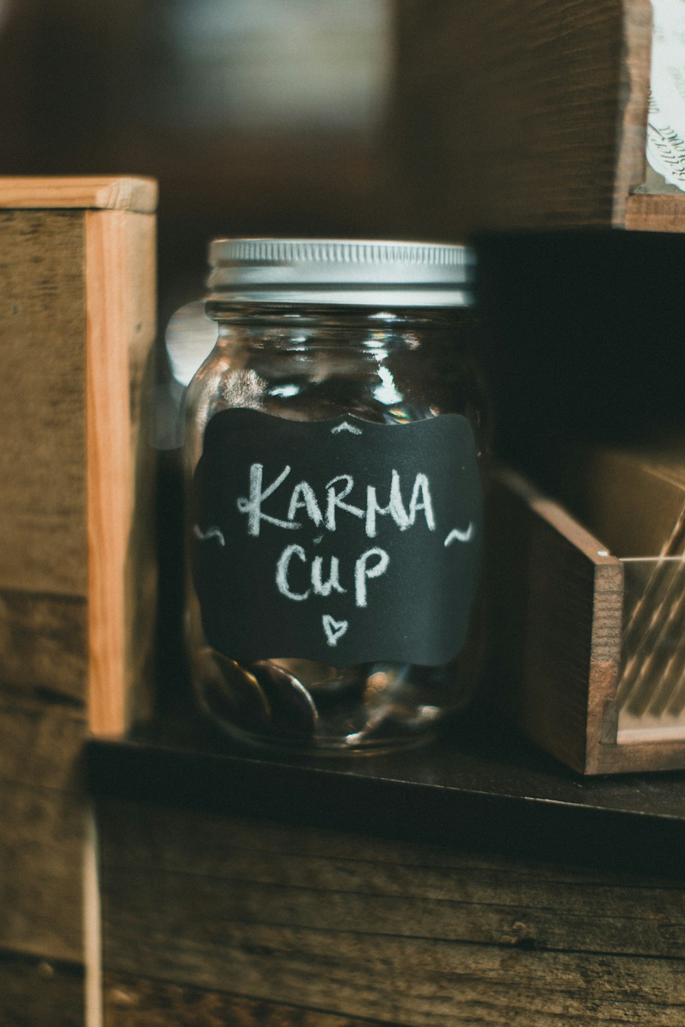 a mason jar with a chalkboard saying karma cup on it