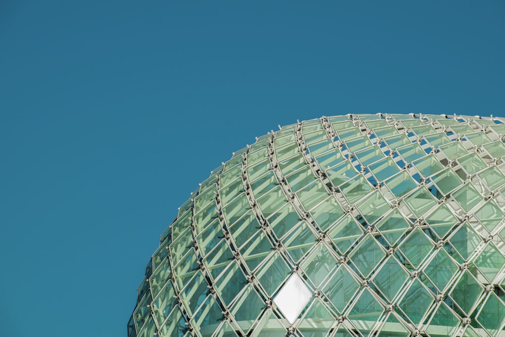 a large glass building with a clear blue sky in the background