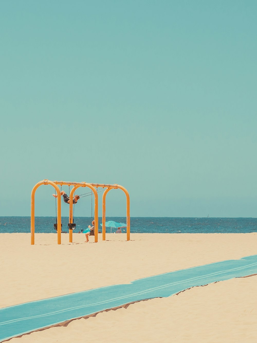 una spiaggia di sabbia con un ombrellone blu e giallo