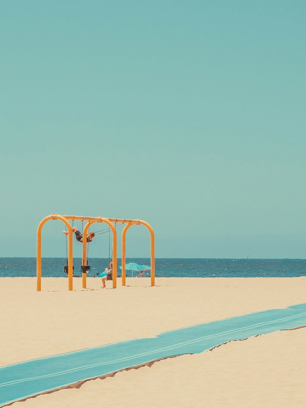 une plage de sable avec un parasol bleu et jaune