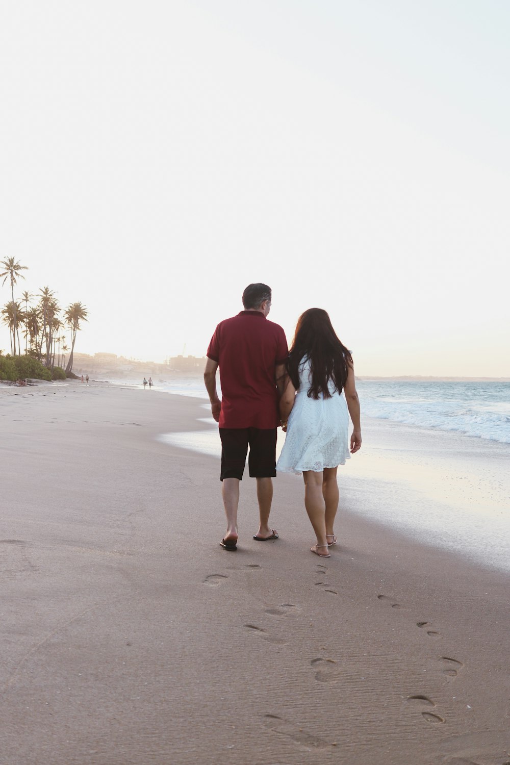 a man and a woman walking along a beach