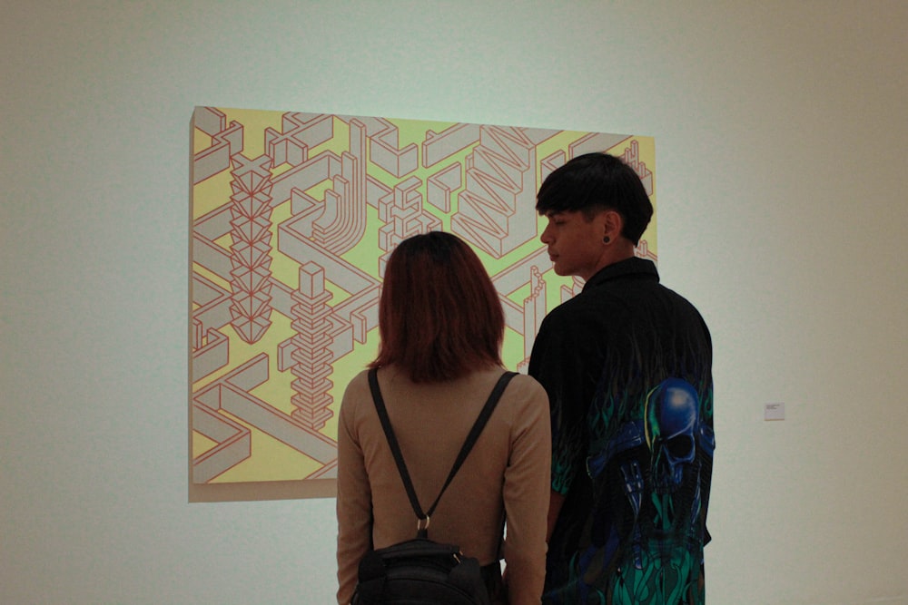 a man and a woman standing in front of a painting