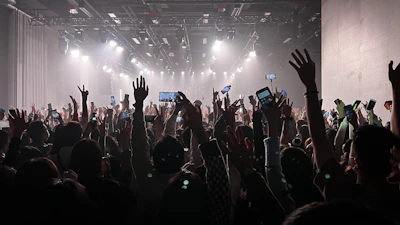 Fans holding up their phones capturing the moment during an energetic live show.