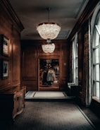 An artfully designed hallway with wooden floors and understated gold lighting details.