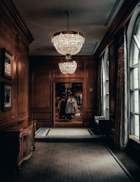 An artfully designed hallway with wooden floors and understated gold lighting details.