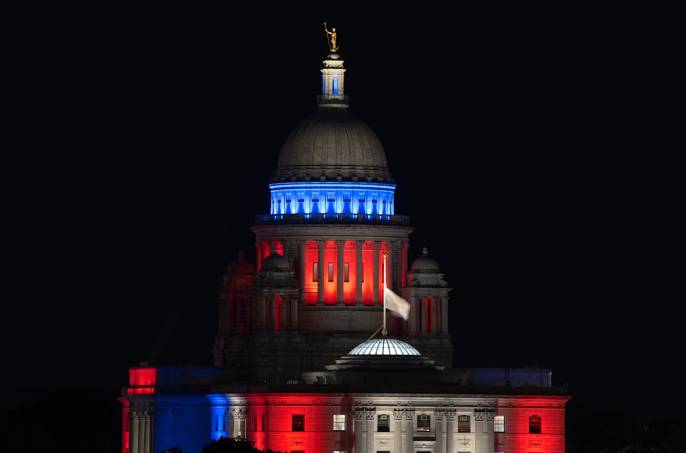 a building lit up with red, white and blue lights