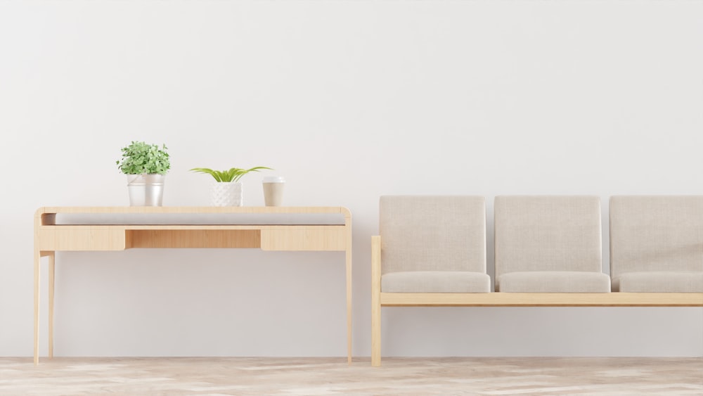 a white wall with a wooden bench and a plant