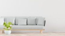 a couch with pillows and a potted plant