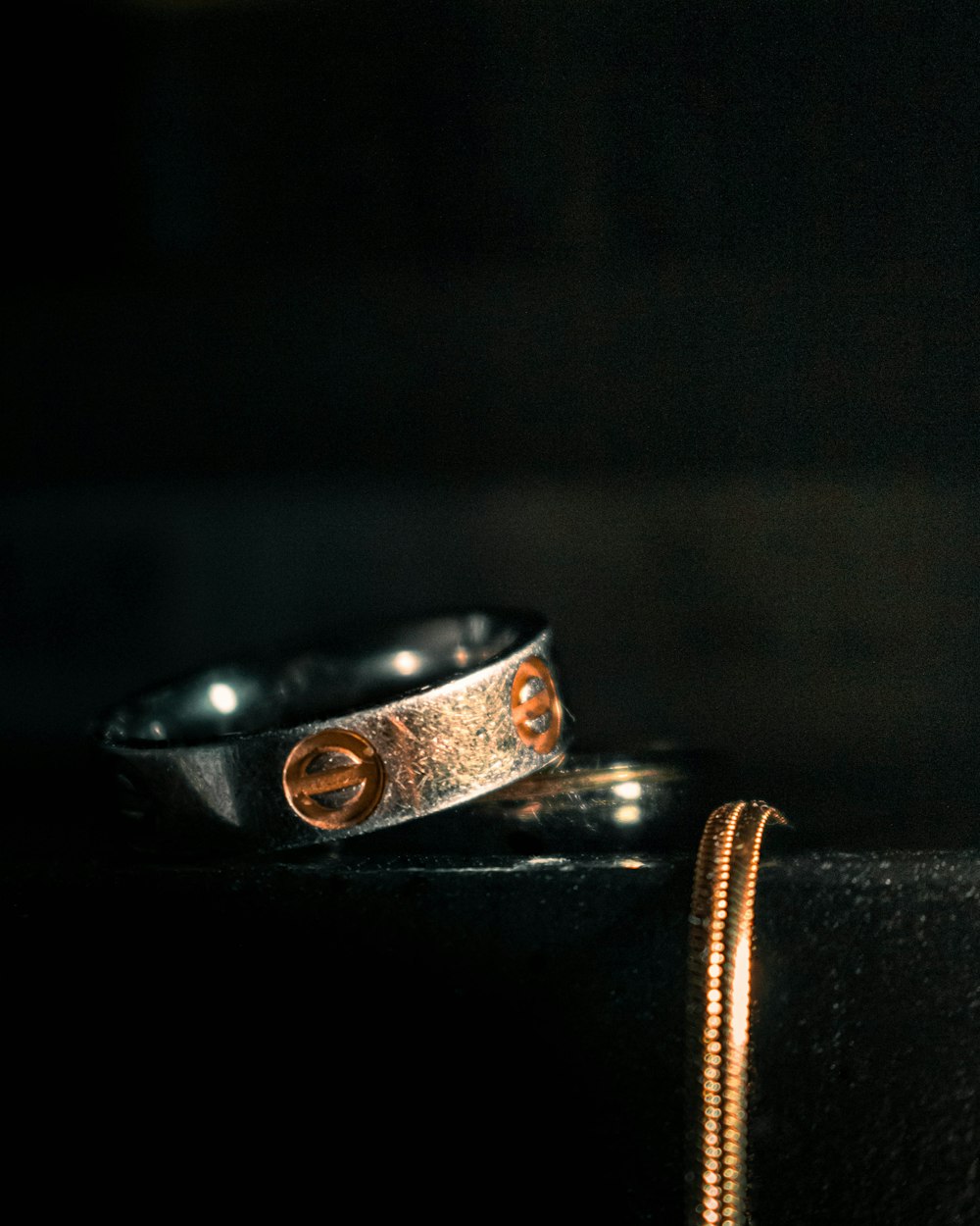 two rings sitting on top of a black table