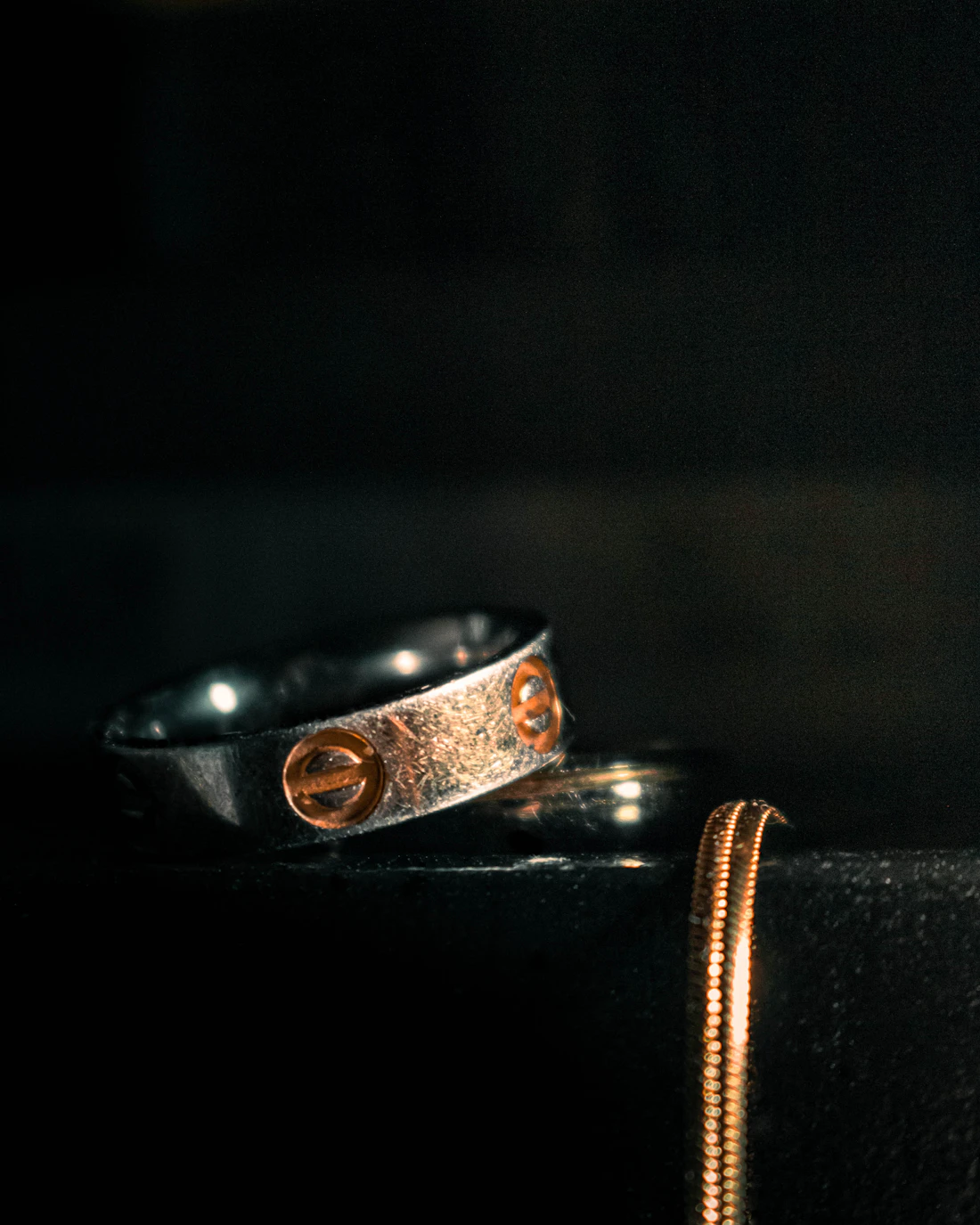 Two rings left on a black table, as if mid-conversation