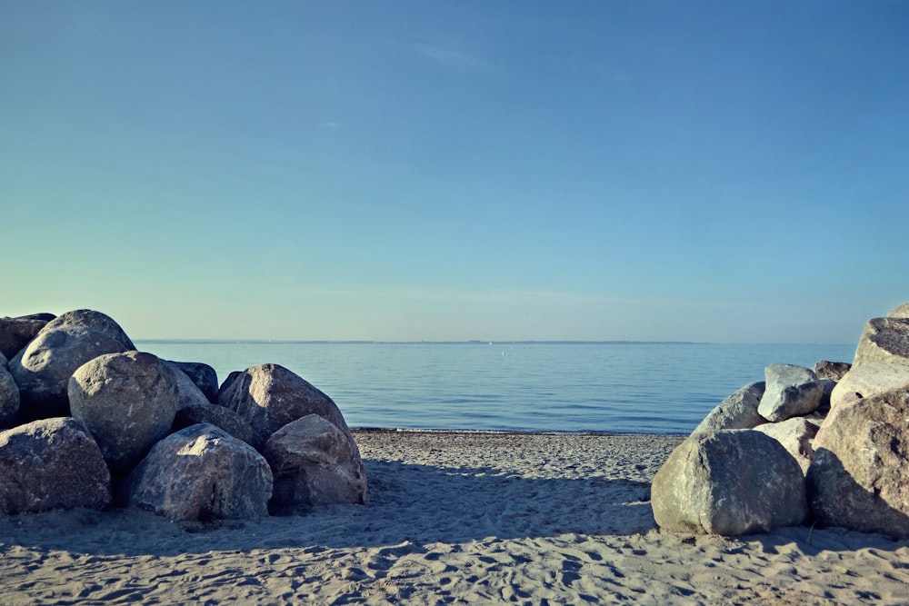 a bunch of rocks sitting on top of a sandy beach