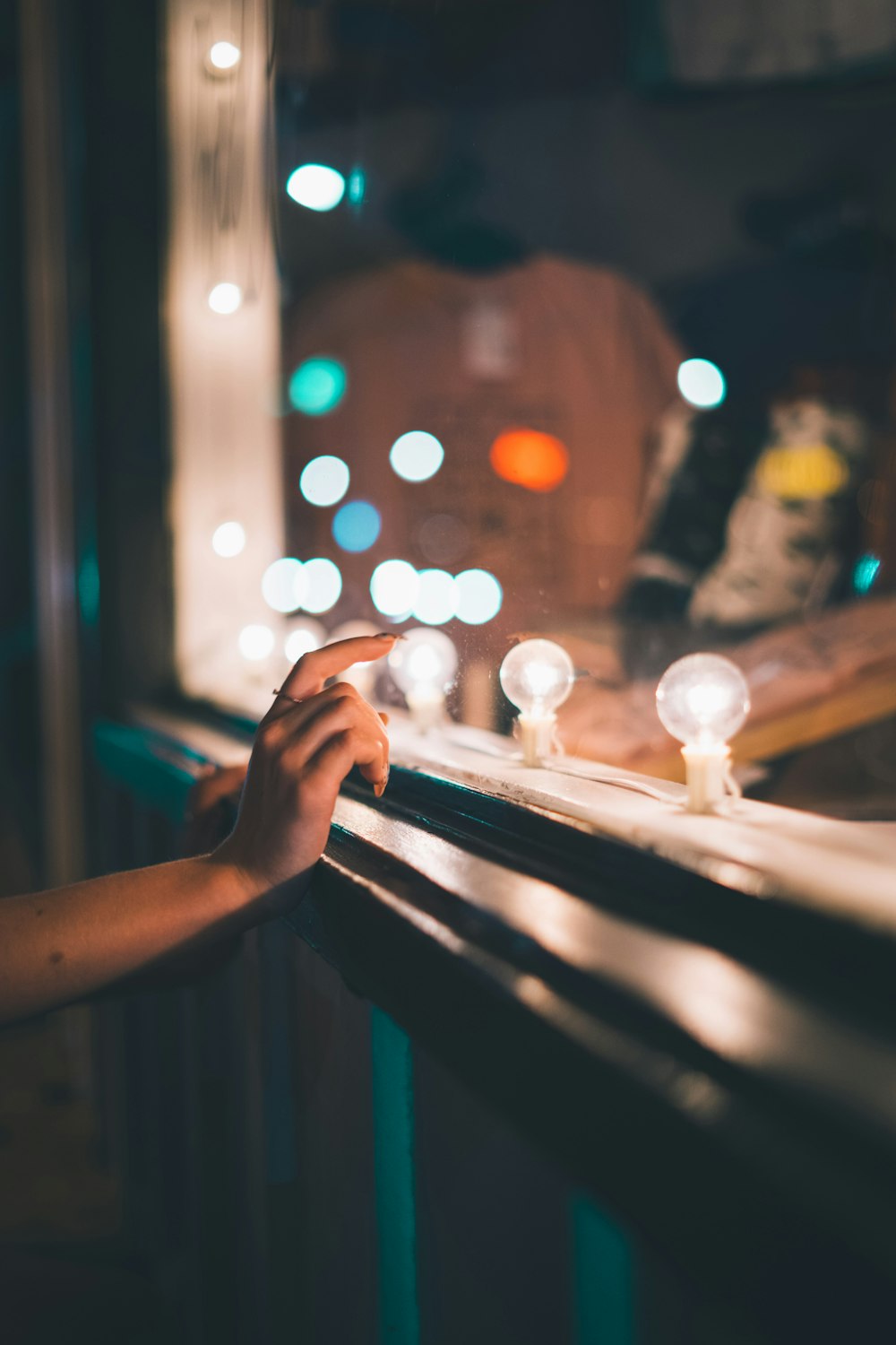 a person reaching out of a window at night