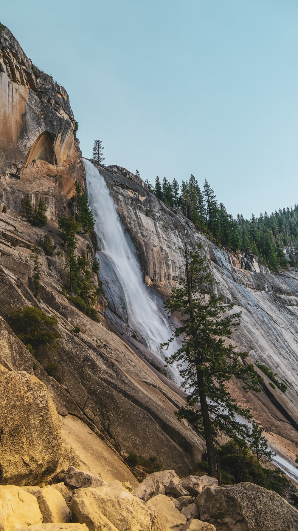 a waterfall is coming out of the side of a mountain