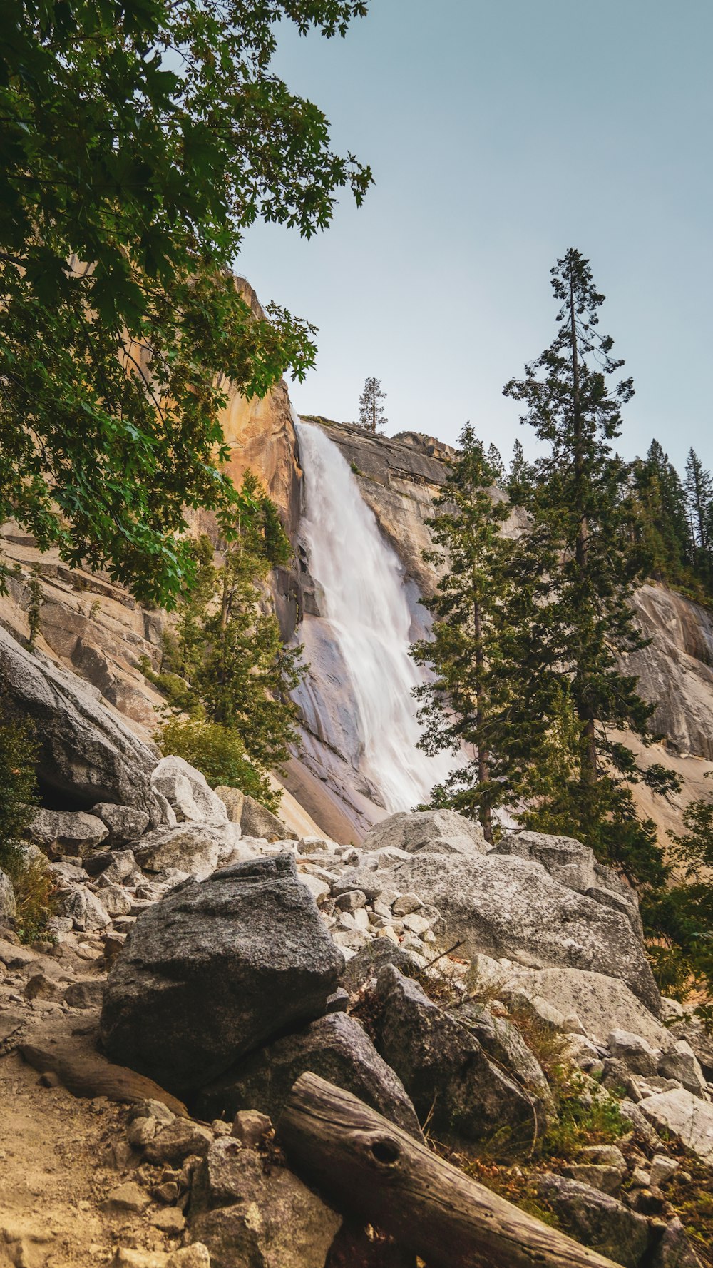 a very tall waterfall in the middle of a forest