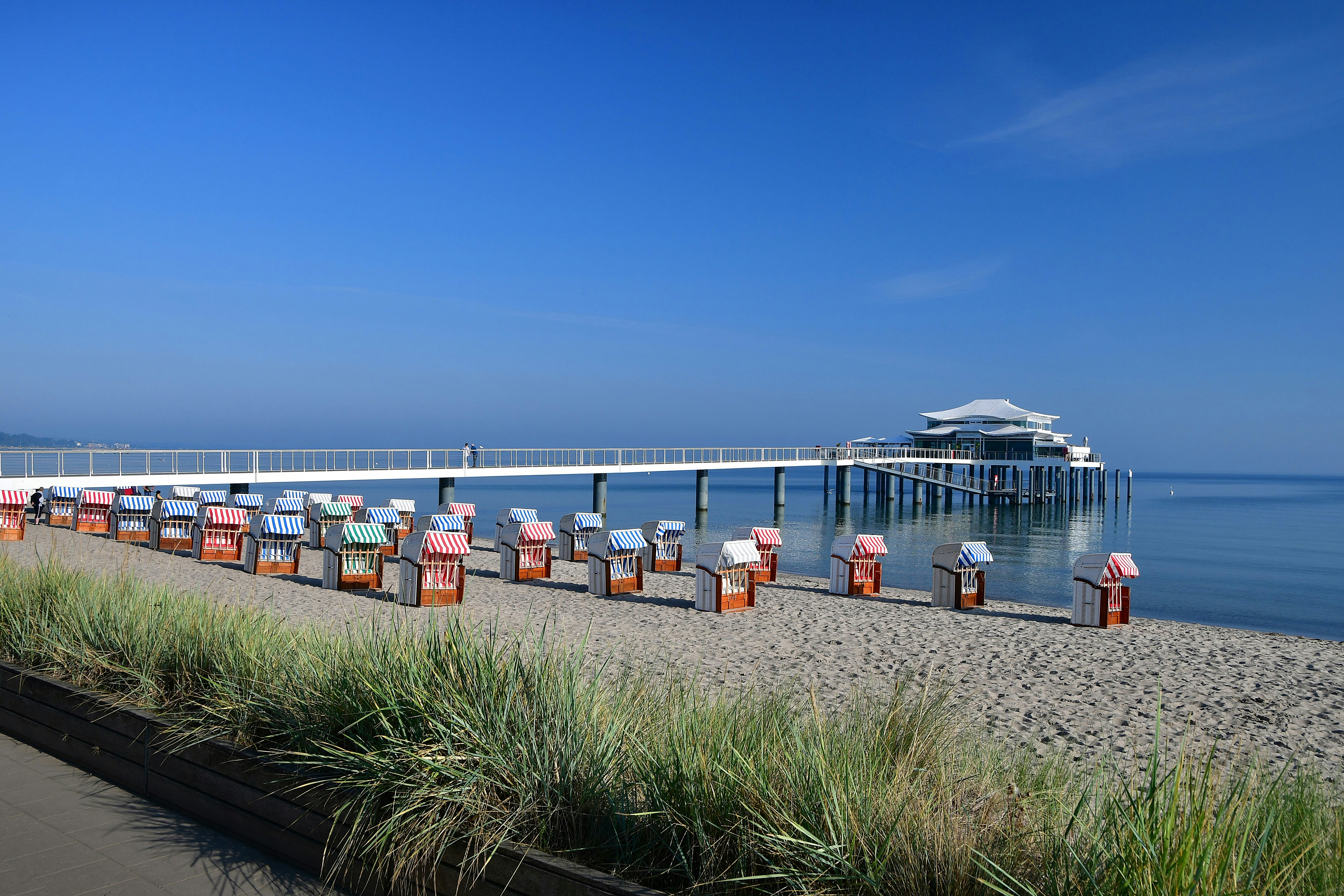 a long row of beach chairs sitting on top of a sandy beach
