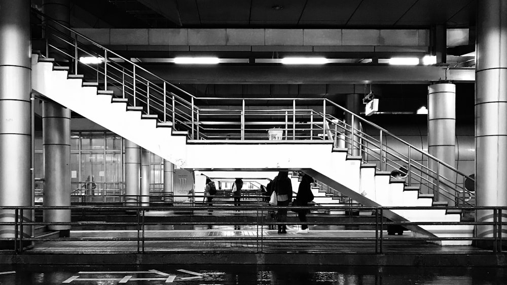 a black and white photo of people walking up stairs