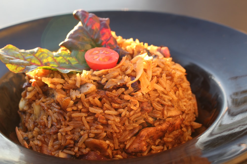 a plate of rice with a tomato on top