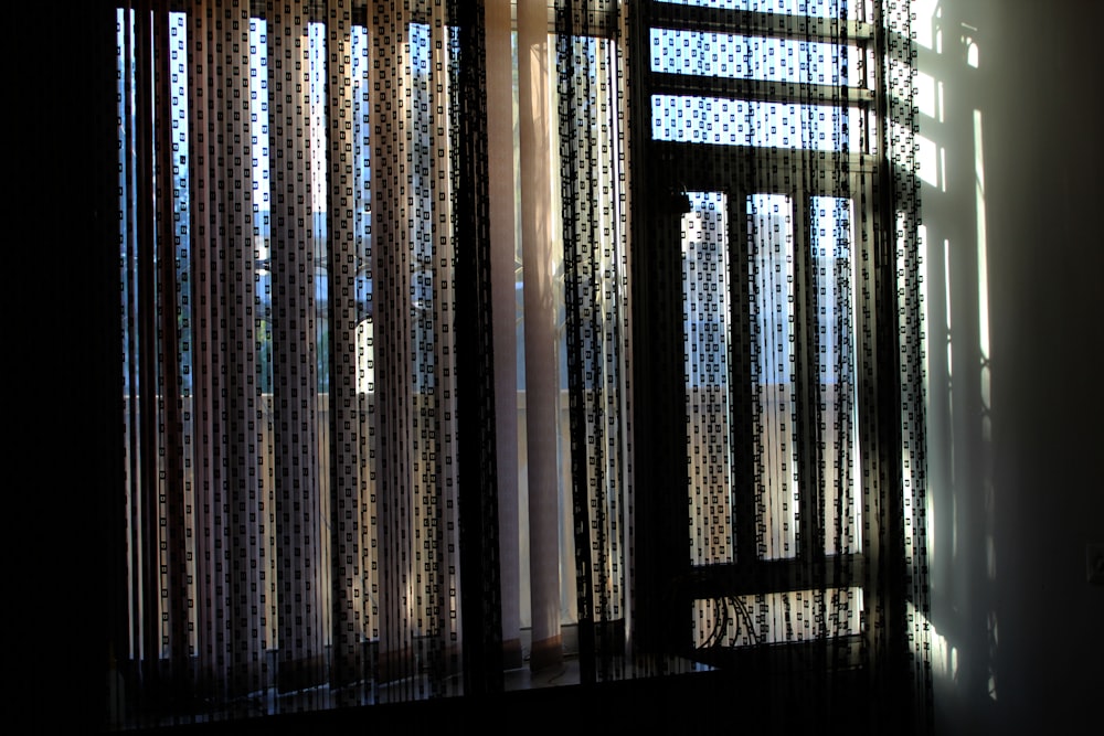 a room with a window covered in sheer curtains