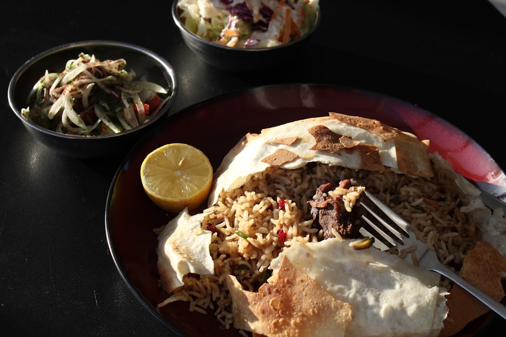 a plate of food with a fork and a bowl of salad