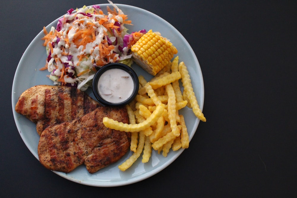 a white plate topped with meat, fries and coleslaw