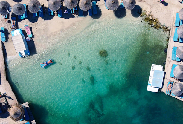 an aerial view of a beach with umbrellas and chairs