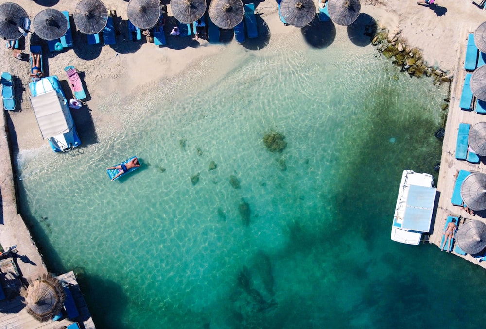 an aerial view of a beach with umbrellas and chairs