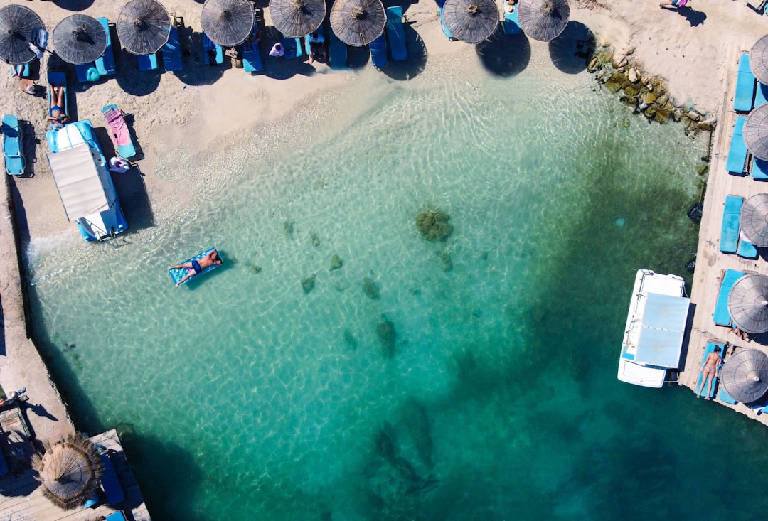 an aerial view of a beach with umbrellas and chairs,