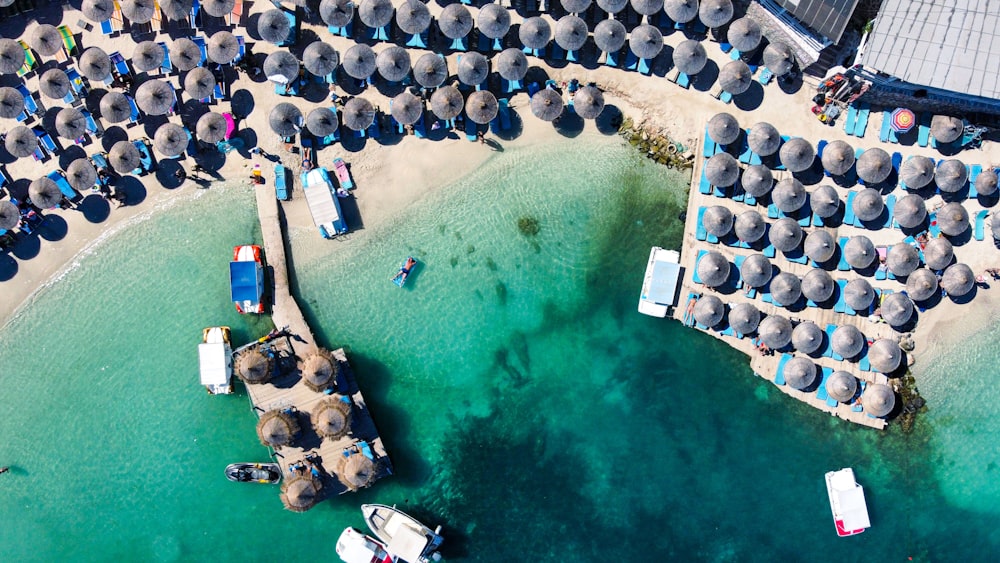 an aerial view of a beach with umbrellas and boats