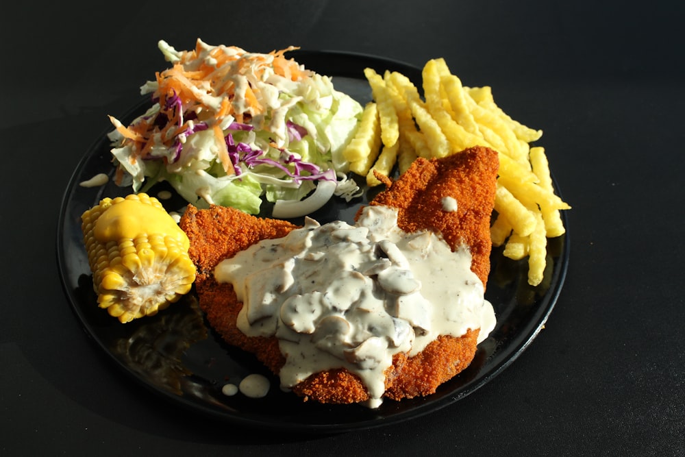 a plate of food that includes fries, coleslaw, and coleslaw