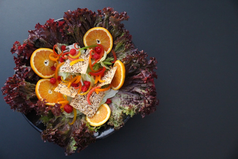 a salad with oranges, cranberries, and sesame seeds