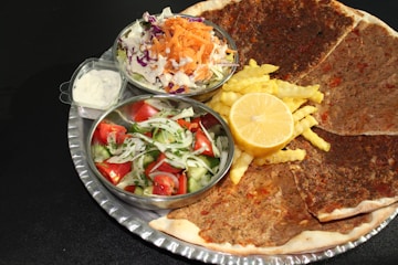 a plate of food that includes pancakes, coleslaw, and a salad