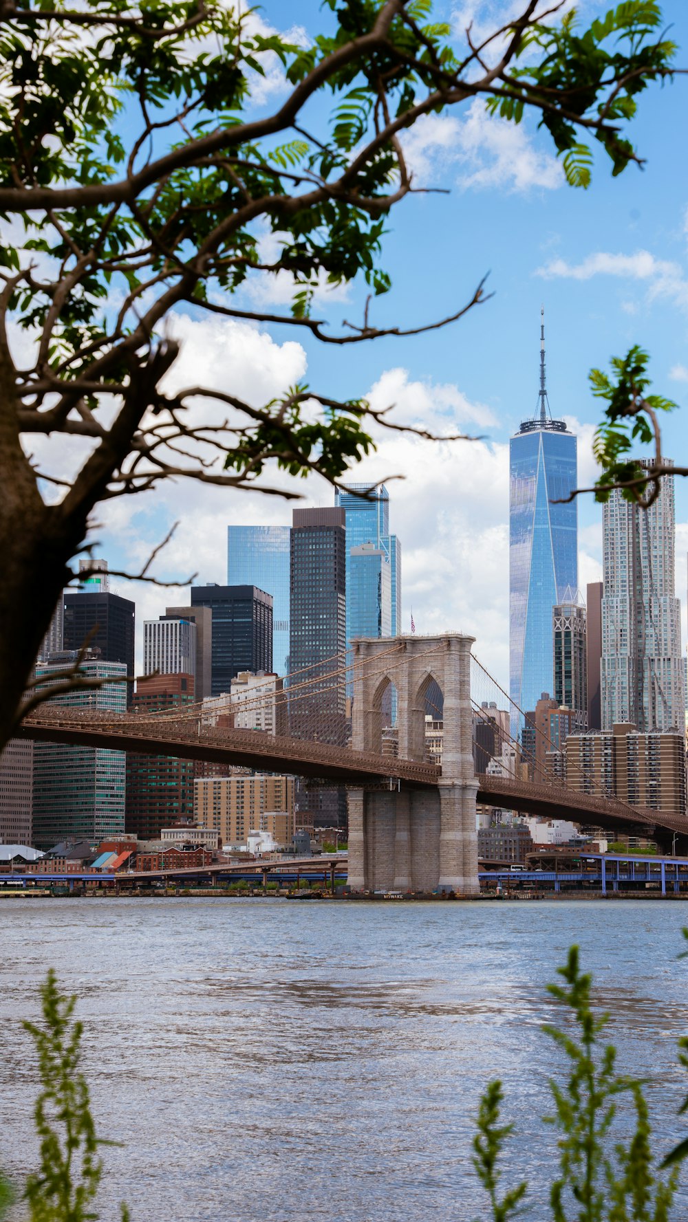 a bridge over a river with a city in the background