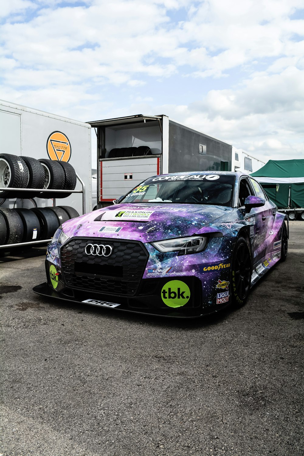 a purple and blue car parked in a parking lot