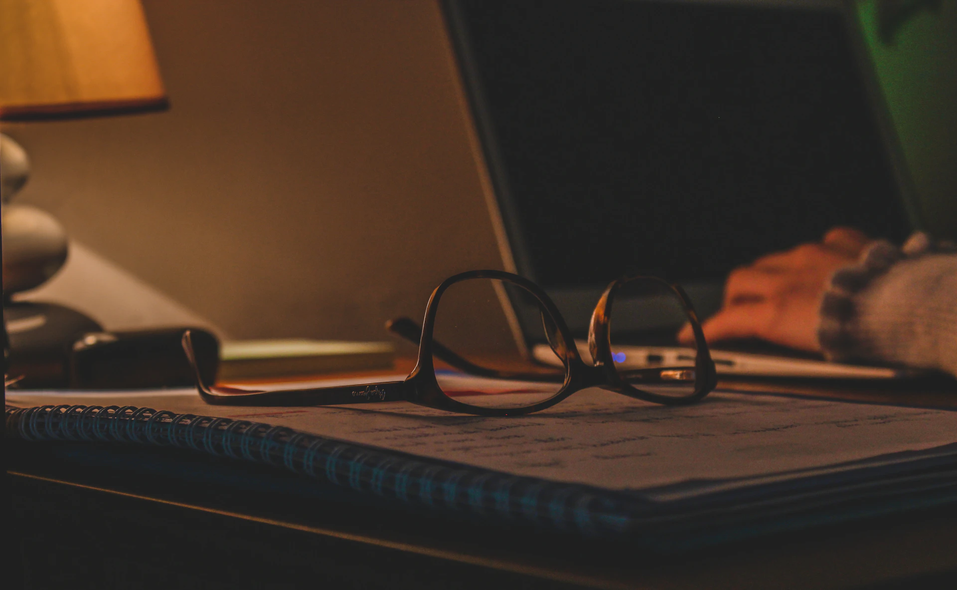 a pair of glasses sitting on top of a notebook