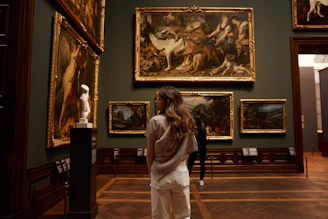 a woman looking at paintings in a museum